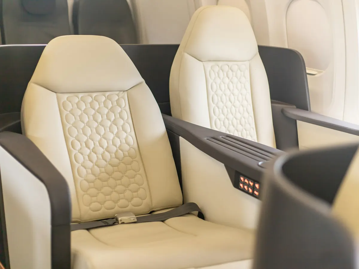 Cream leather seat beside an oval window in a private jet