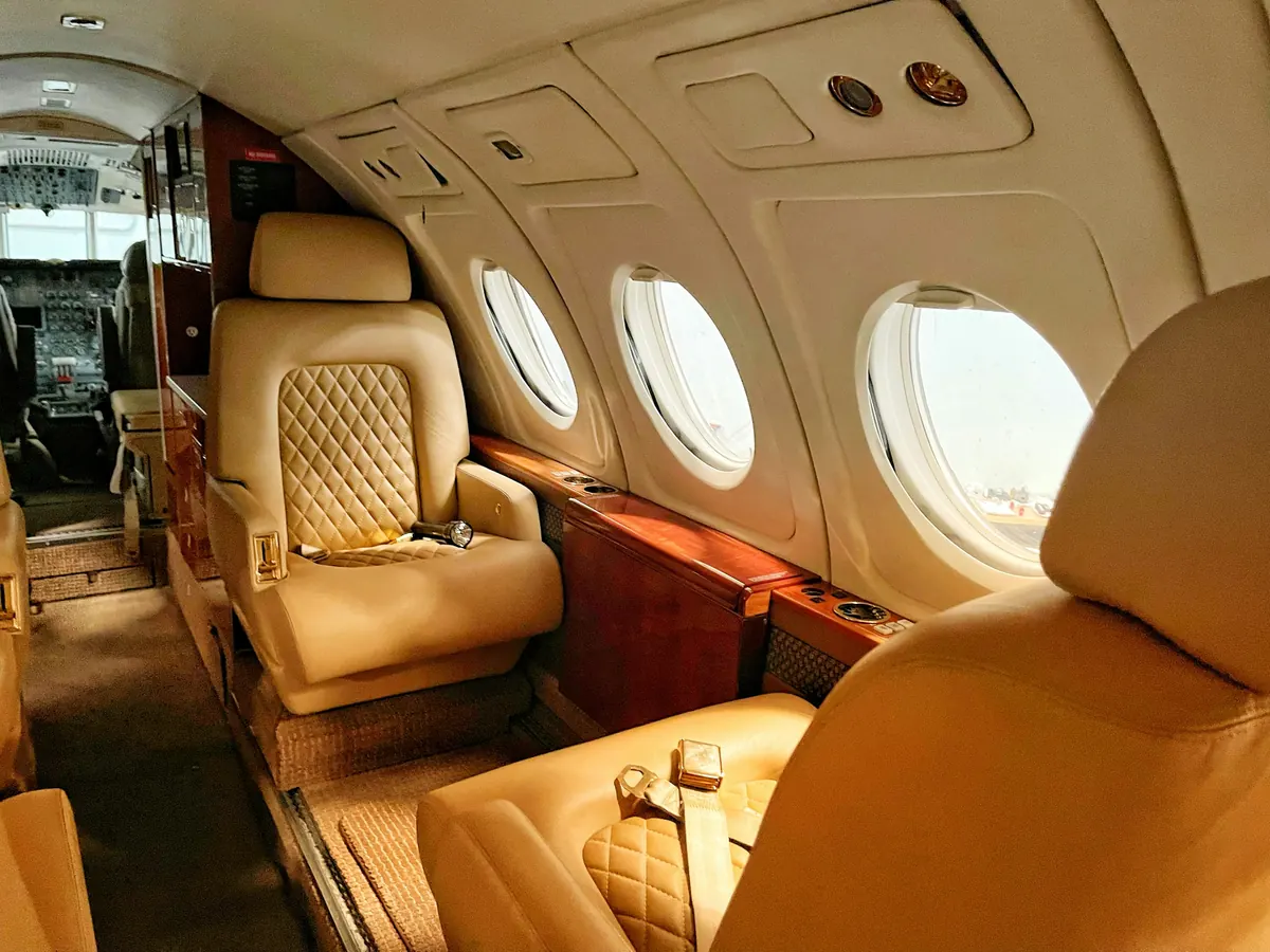 Private jet cabin with quilted leather seats and wood trim