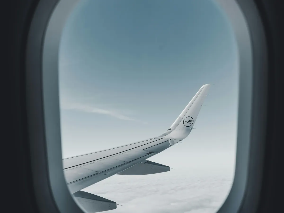 Wing and cloud tops seen through an aircraft window