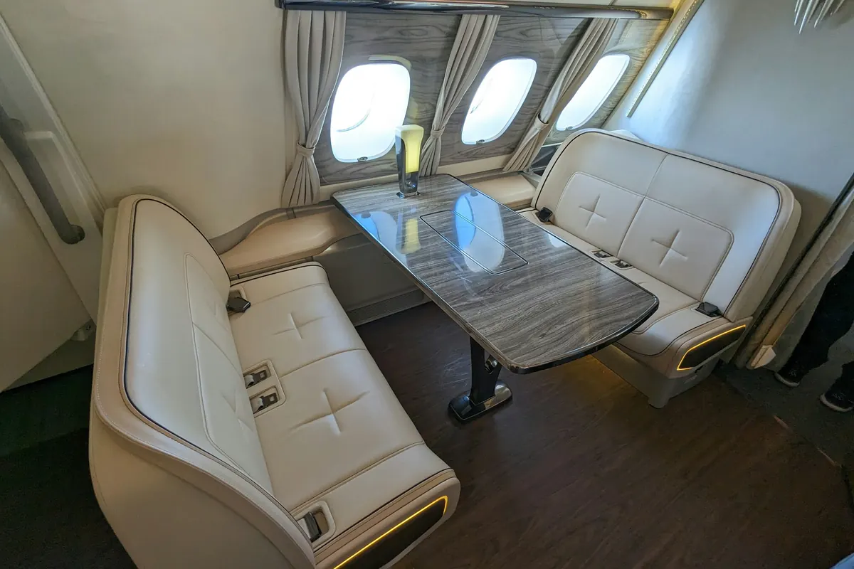 Private jet cabin with facing club seats around a polished table