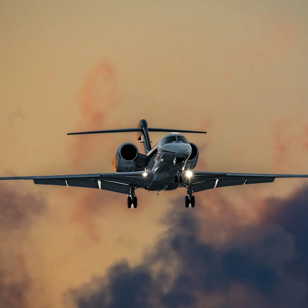 Business jet descending through layers of cloud